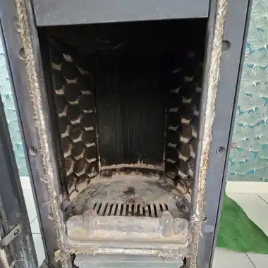 Chambre de combustion d’un poêle encrassée, avant démontage et entretien